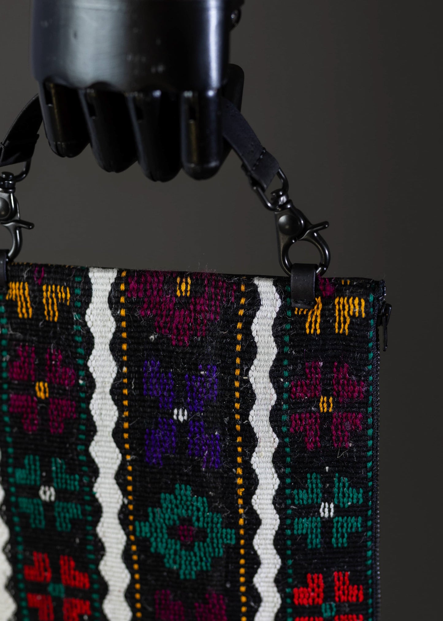 Detailed view of FTLO bag's handwoven floral and striped patterns in vivid colors.