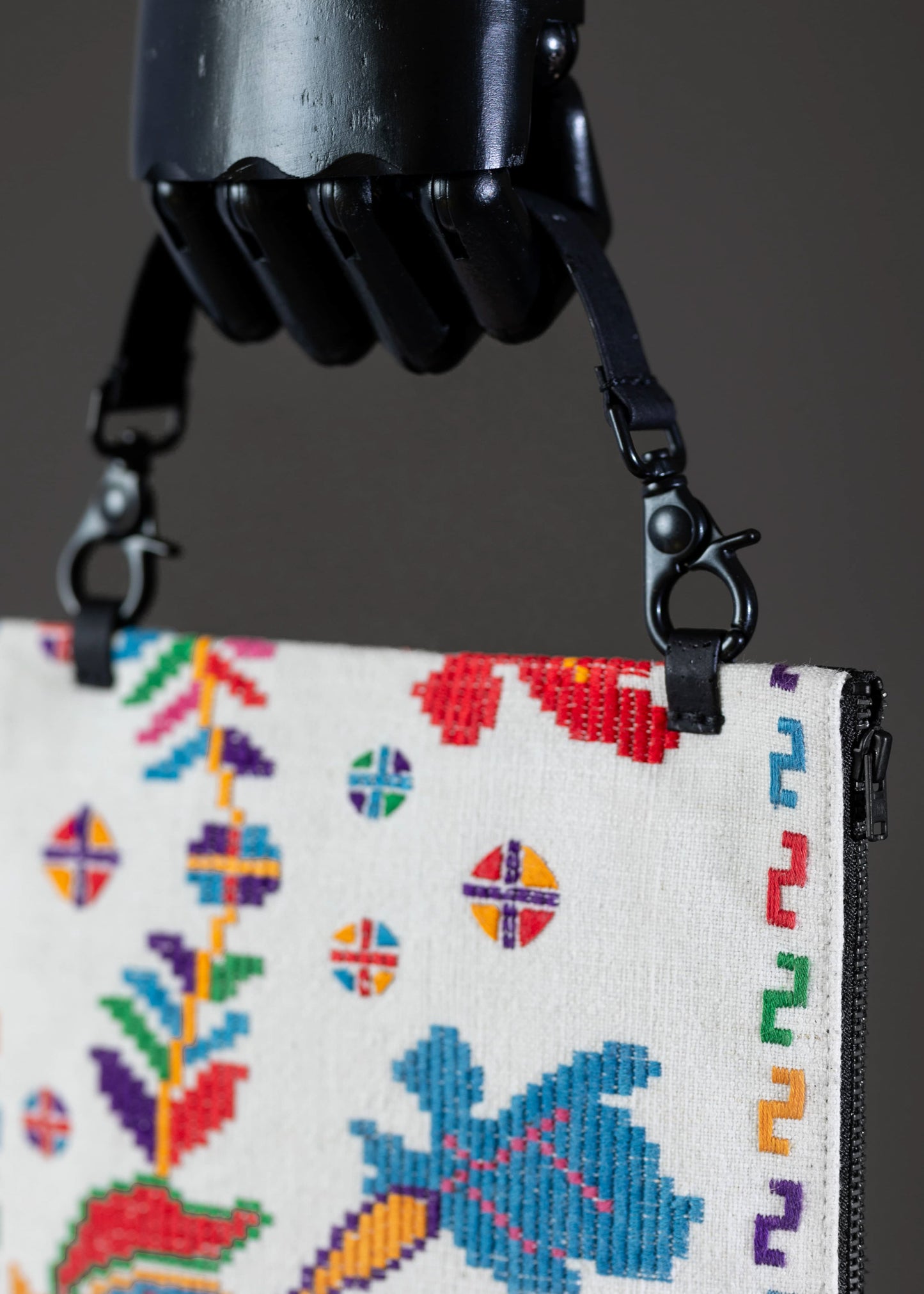 Detail of FTLO clutch's embroidery, emphasizing the vivid colors and traditional craftsmanship.