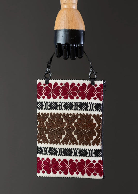 Front view of FTLO clutch with earthy brown and red traditional motifs.