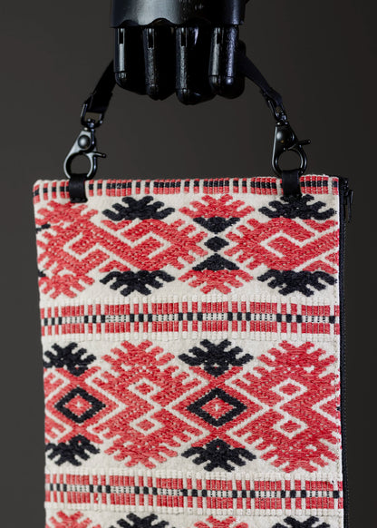 Close-up of the traditional geometric embroidery on FTLO's red and black Romanian handwoven bag.