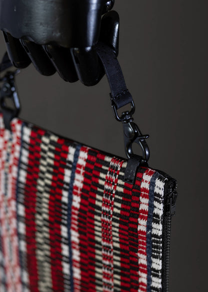 Close-up detail of FTLO red and white geometric patterned clutch.