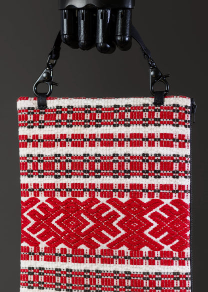 Close-up of the red geometric patterns and embroidery on FTLO's Romanian handwoven bag.