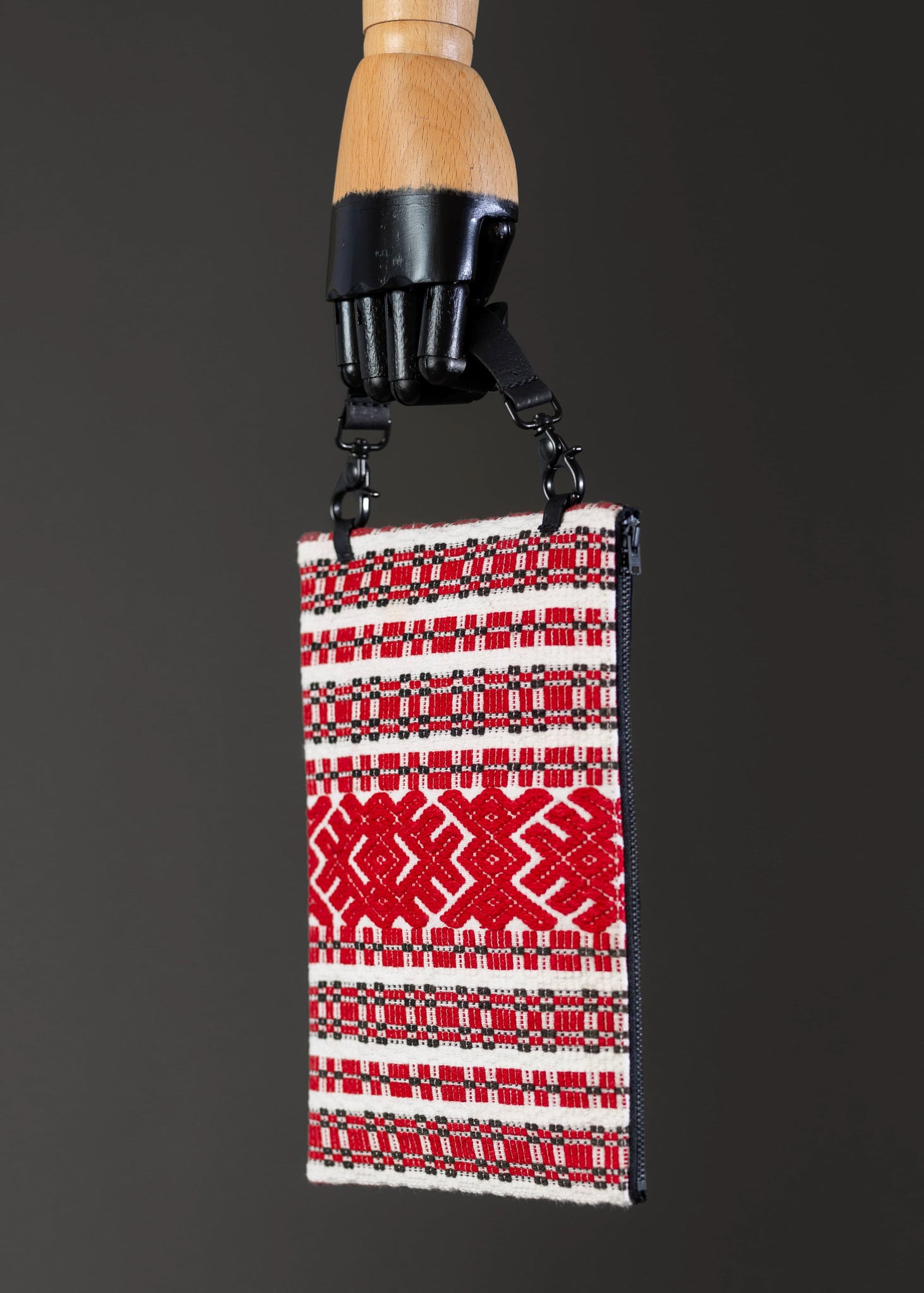 Side view of FTLO handwoven bag with red geometric patterns and vintage Romanian embroidery.