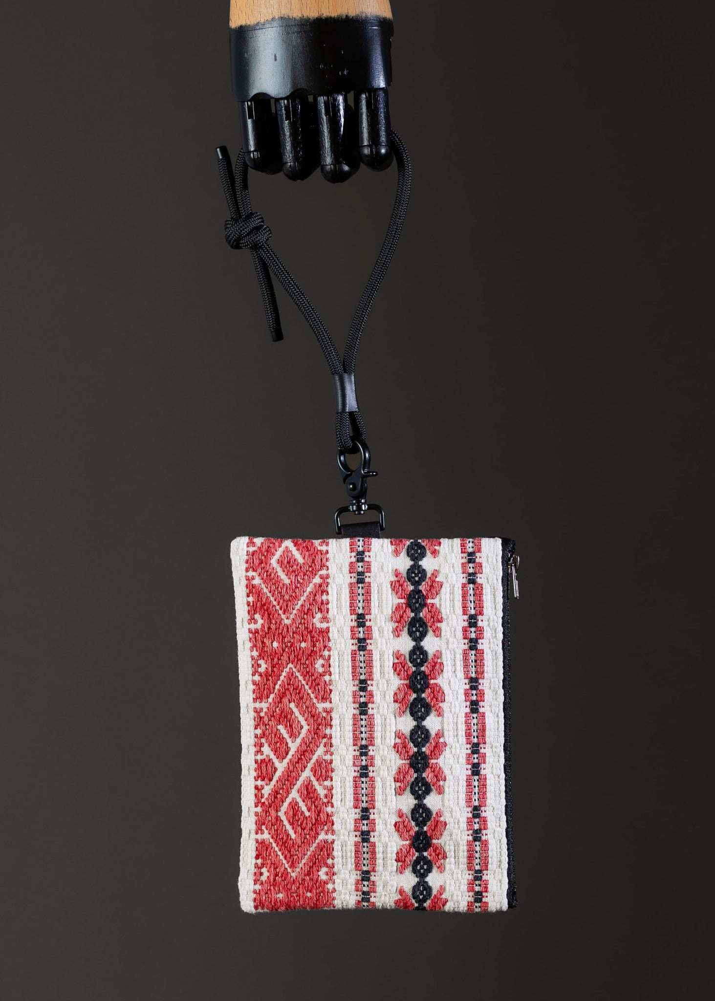 Front view of the small FTLO red and black striped bag with traditional motifs.