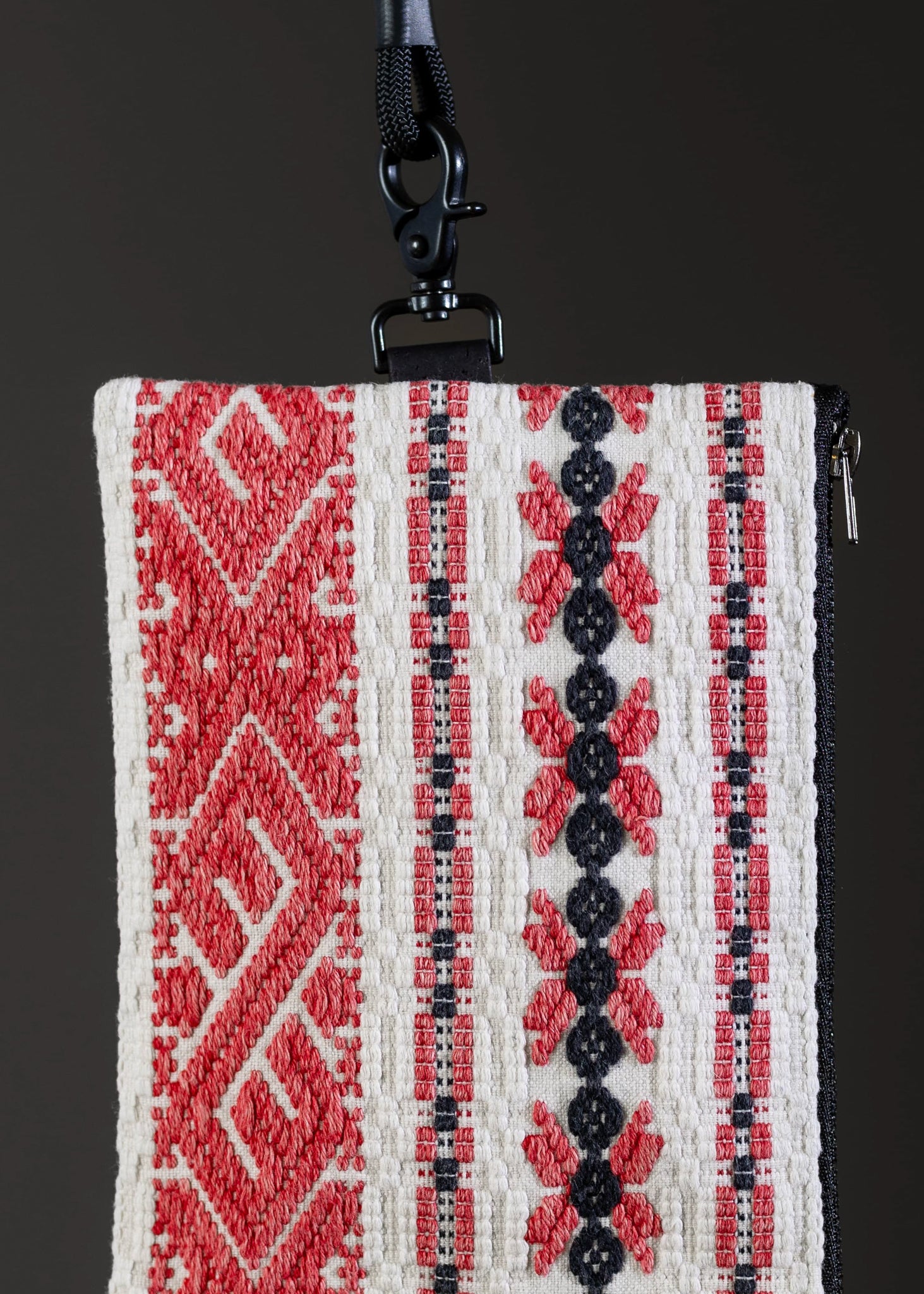 Detailed motif view of the small FTLO bag's traditional red and black stripes on white fabric.